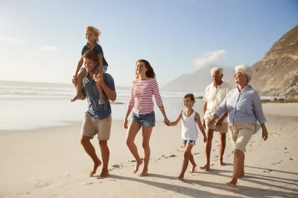 multi-generation-family-vacation-walking-along-beach-together-multi-generation-family-vacation-walking-along-beach-together-113668844
